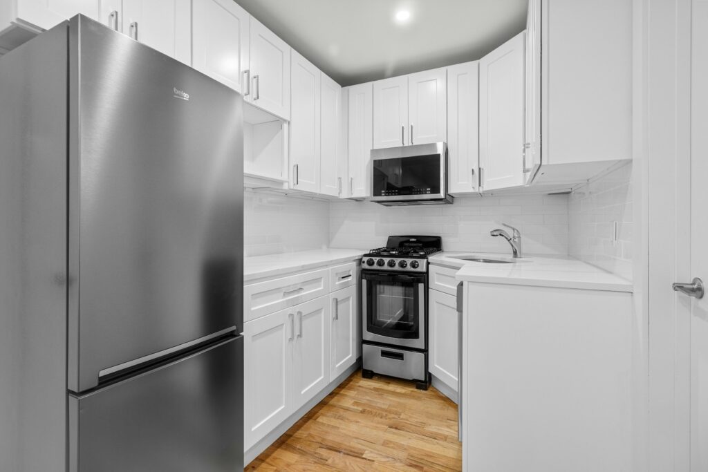 A kitchen with white cabinets and stainless steel appliances