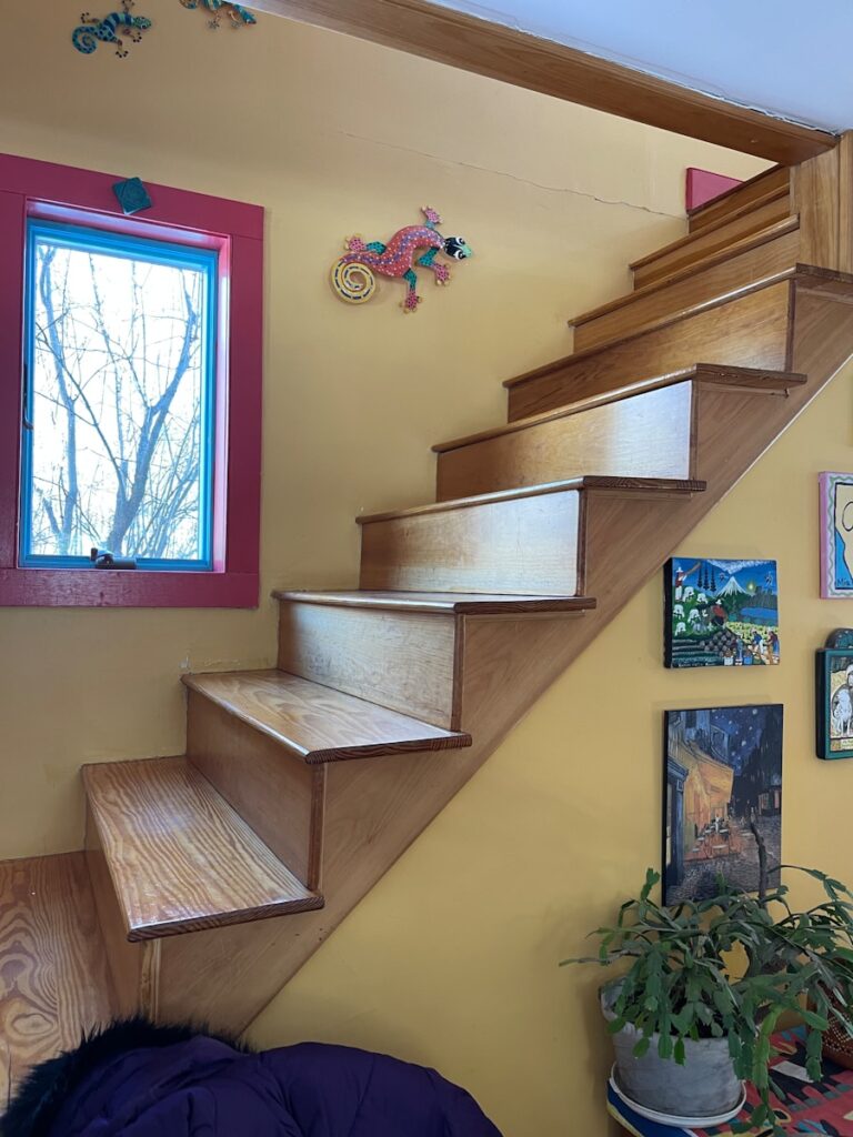 a room with a window and a stair case