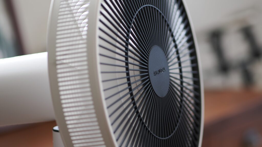 a white fan sitting on top of a wooden table